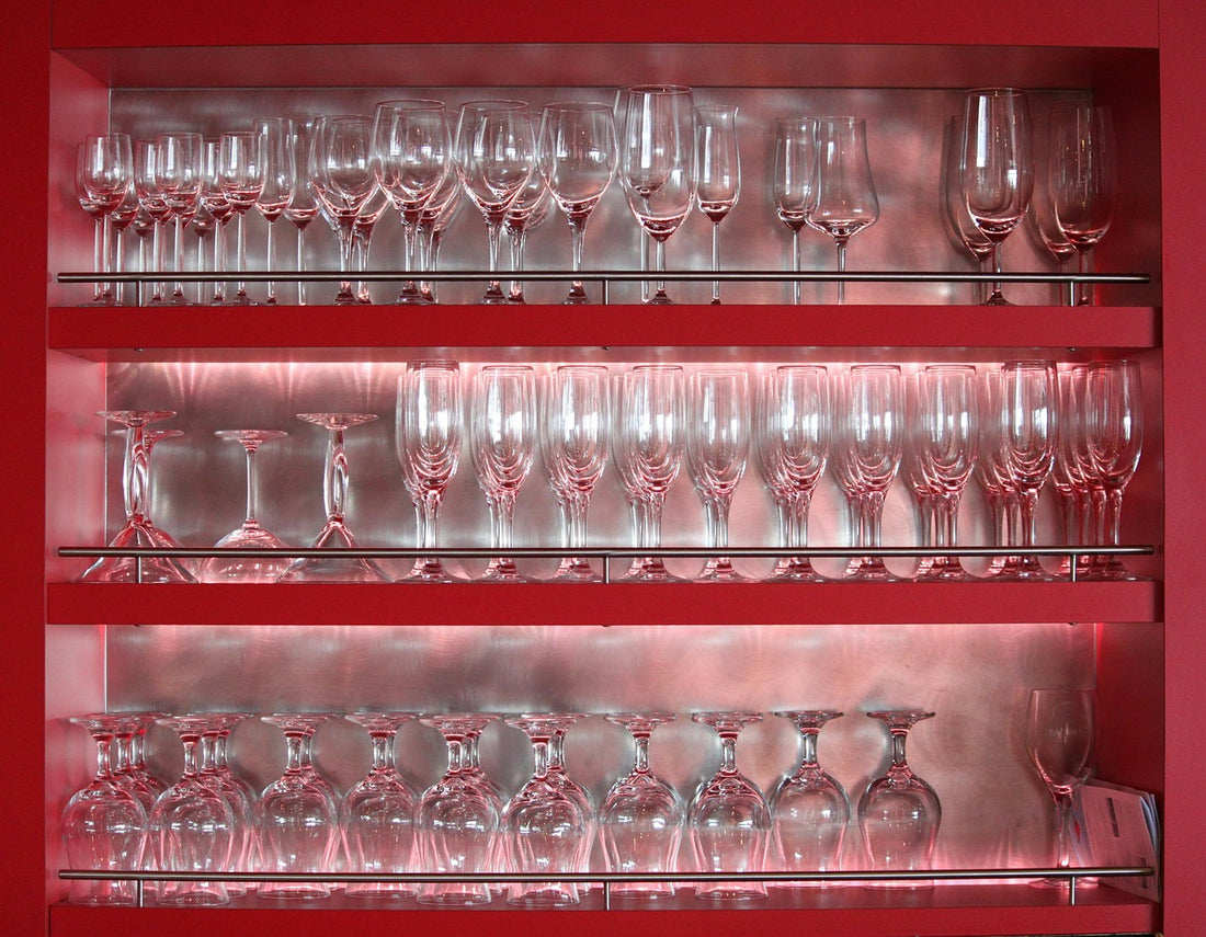 Ein Gläserschrank mit roten Fächern und indirekter Vitrinenbeleuchtung
