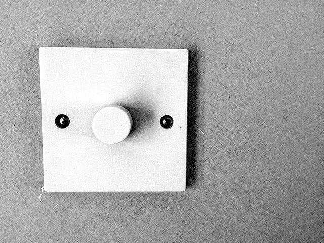 Ein Lichtschalter mit Dimmer an einer Wand