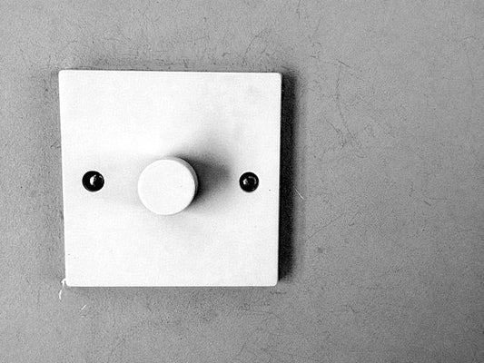 Ein Lichtschalter mit Dimmer an einer Wand