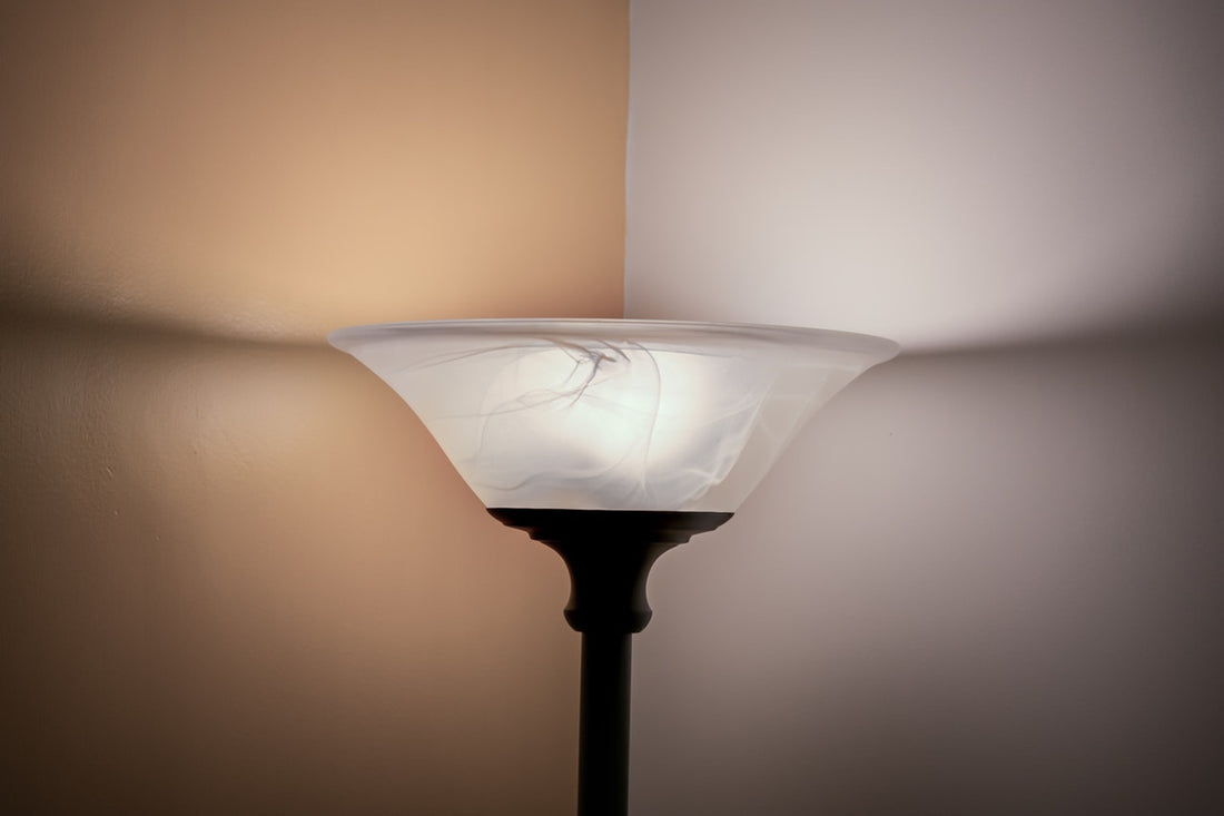 Seiten einer gelben und einer weißen Wand in der Ecke steht ein Deckenfluter, der Licht abstrahlt.