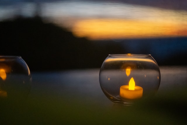 Ein elektrisches Teelicht in einem Glas vor einem Sonnenuntergang