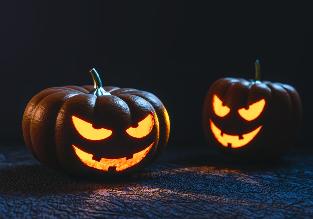 Zwei selbstgeschnitzte Halloween Kürbisse, die im Dunkeln gruselig leuchten