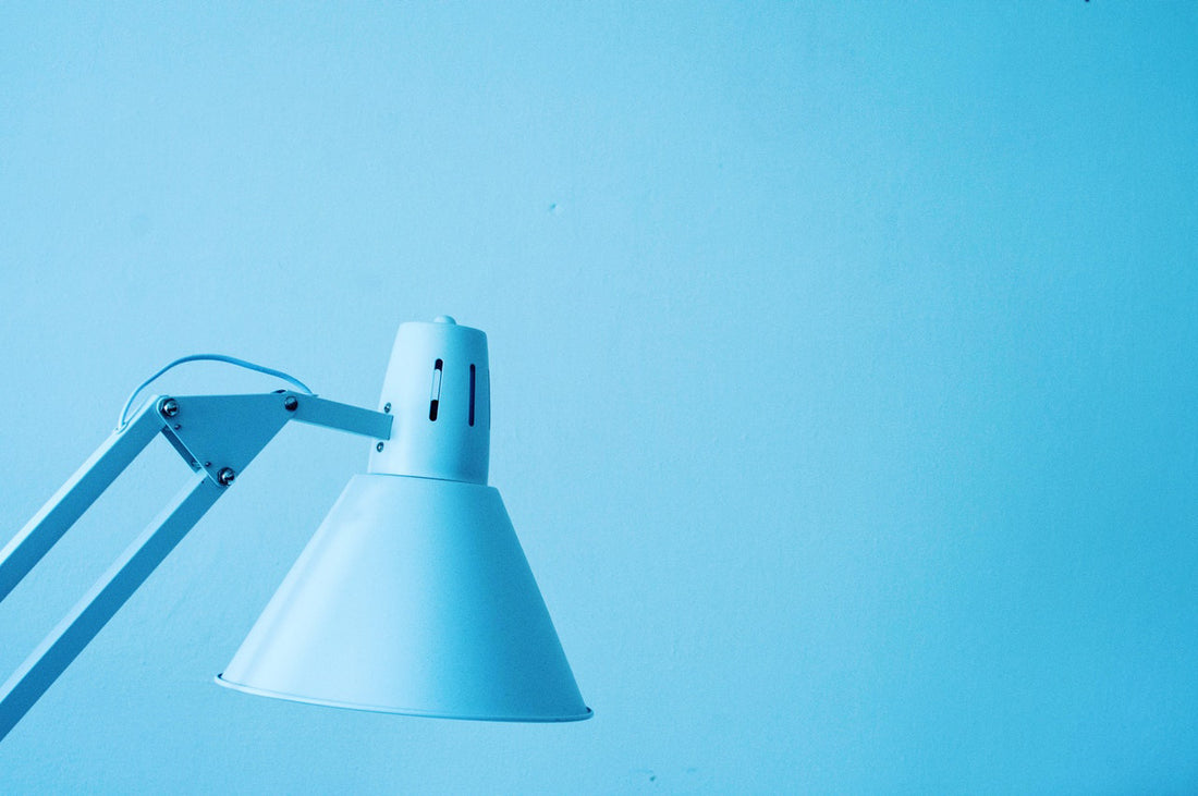 Ein hellblauer Lampenschirm einer Schreibtischlampe für Kinder vor hellblauem Hintergrund