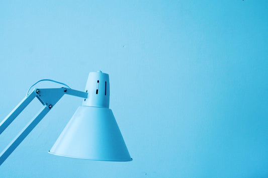 Ein hellblauer Lampenschirm einer Schreibtischlampe für Kinder vor hellblauem Hintergrund
